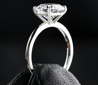 A diamond ring held between two fingers - Ingenuity Diamonds NEWS