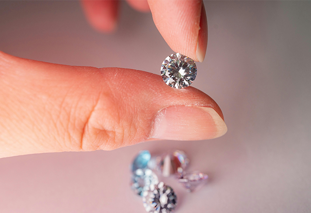 Fingers holding lab-grown diamond