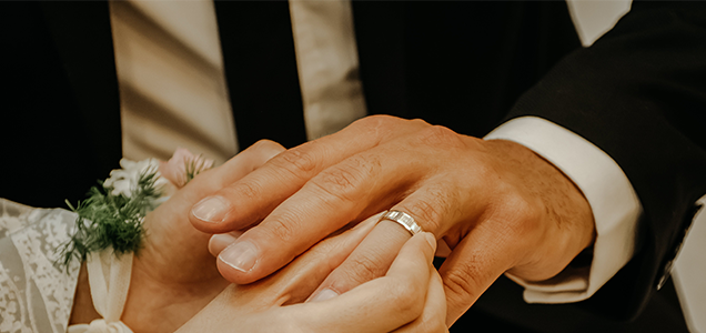 A woman is giving her husband a diamond engagement ring